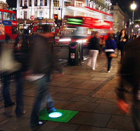 L'immagine riprende il momento in cui una mattonella Pavegen viene calpestata e produce energia illuminando una lampadina in Westfield Stratford City