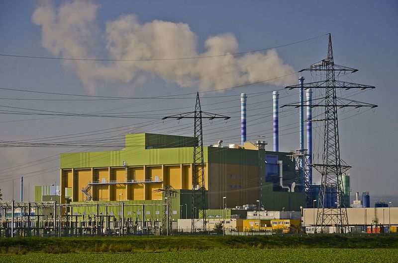 L'immagine ritrae un inceneritore in funzione mentre le sue canne fumarie espellono molto fumo