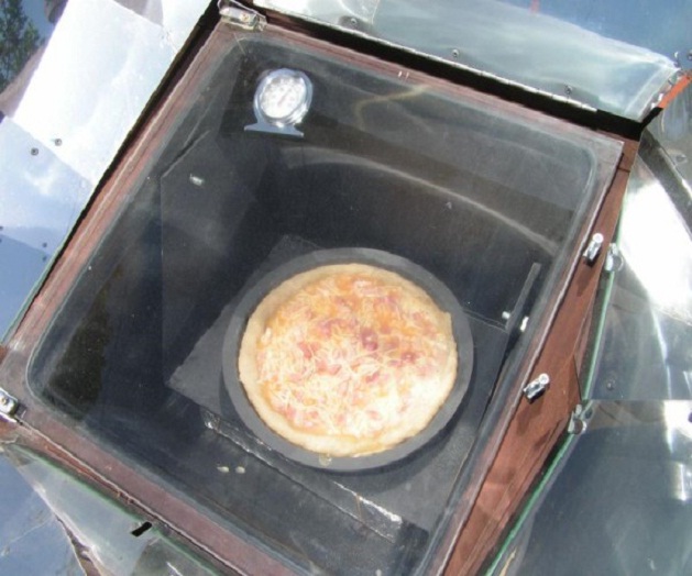 Un forno solare usato per cuocere una pizza