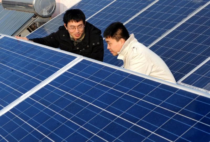 Uomini orientali addetti al montaggio di pannelli fotovoltaici
